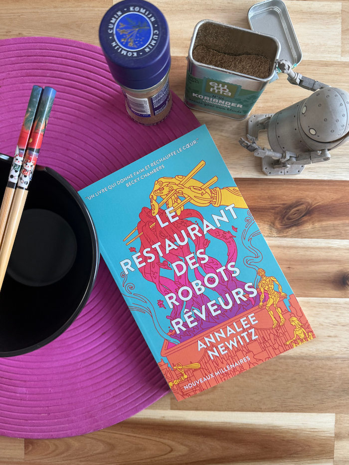 Livre Le restaurant des robots rêveurs avec un bol et des baguettes, un robot et des épices