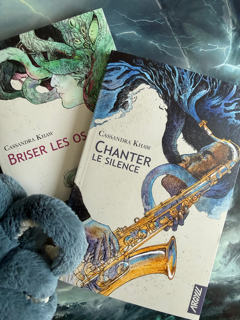 Livre Chanter le silence avec le livre Briser les os, un poulpe et une illustration de Cthulhu en fond