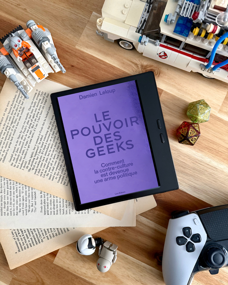  une manette de playstation, un lego Ghostbuster, deux dés 20, des pages du Seigneur des anneaux, un Lego Star Wars et deux figurines NieR Automata