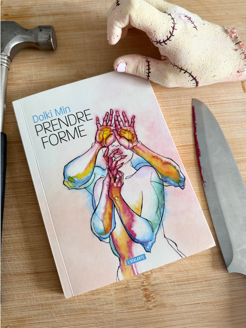 Livre Prendre forme avec un couteau avec du faux sang, un marteau et une main découpée sur une planche à découper
