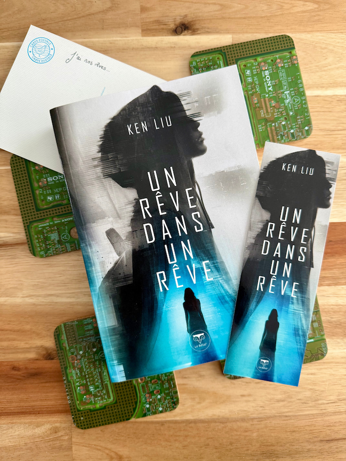 Livre Un rêve dans un rêve sur des plaques de circuits imprimés et une carte postale « J’ai nos rêves… »